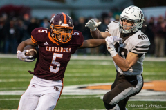 Mount Carmel's Nickolas Naujokas (40) grabs an arm of  Brother Rice's Aaron Vaughn (5) during the Class 7A quarterfinal game, in Chicago on Saturday Nov. 13, 2021.  (Vincent D. Johnson/for the Daily Southtown).